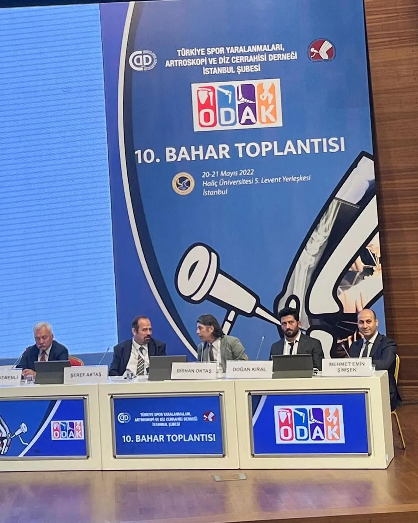 TUSYAD ODAK 10. Bahar Toplantısı panelinde isim tabelalarıyla oturan beş ortopedi uzmanı